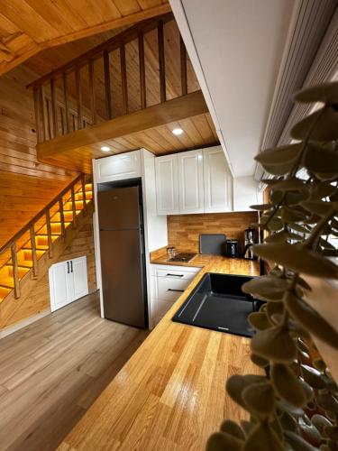 a kitchen with white cabinets and a stainless steel refrigerator at Cebel Tiny House&Bungalovs in Kemer