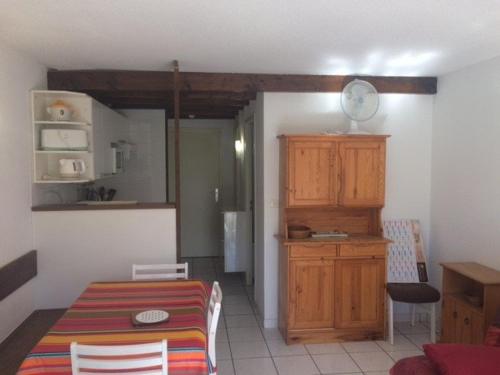 une cuisine et une salle à manger avec une table et un meuble dans l'établissement Appartement T2 en rez-de-chaussée avec terrasse, proche plage et piscine - 4 couchages - Argelès-sur-Mer - FR-1-388-40, à Argelès-sur-Mer