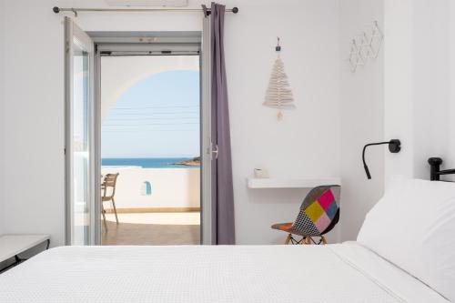 una camera da letto bianca con vista sull'oceano di HH Summer a Logaras