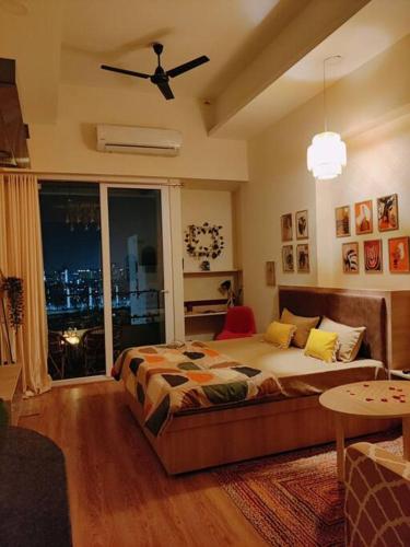 a bedroom with a bed and a large window at Boho Suite by Hey Studios in Ghaziabad
