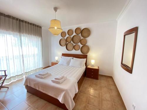 een slaapkamer met een bed met twee handdoeken erop bij Aloha Burgau Guesthouse in Burgau