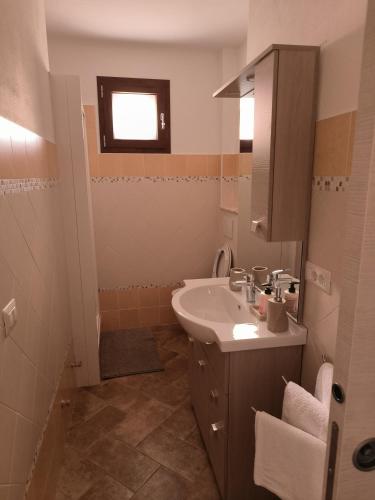a small bathroom with a sink and a mirror at Le stanze del moro house in Pállare