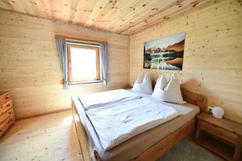 - une chambre avec un lit dans une cabane en bois dans l'établissement Hansstadl, 