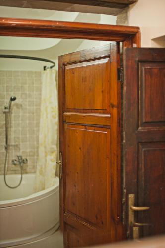 a bathroom with a wooden door and a bath tub at La Vittoria 10 – La Soglia della Val d’Orcia in Chianciano Terme