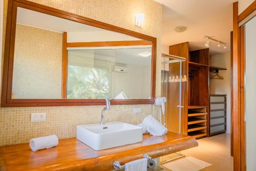 a bathroom with a white sink and a mirror at La Torre Resort All Inclusive in Porto Seguro