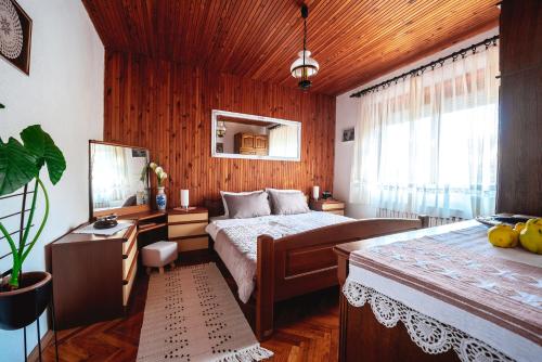 a bedroom with a bed and a wooden wall at Grandma's apartment in Velika