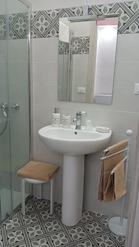 a bathroom with a sink and a mirror and a shower at Le 3 Dee in Reggio Calabria