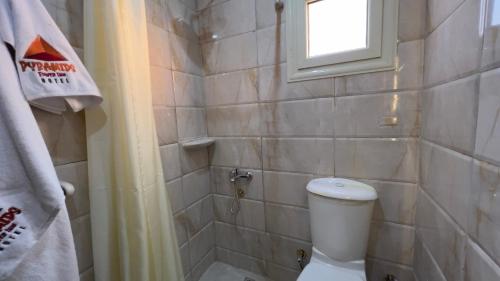 a small bathroom with a toilet and a window at Pyramids Tower view inn in Nazlat as Sammān