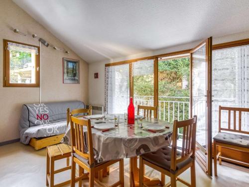 une salle à manger avec une table, des chaises et un canapé dans l'établissement Duplex T3 à Barèges avec parking privatif - FR-1-403-15, à Barèges