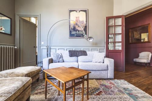 un salon avec un canapé et une table dans l'établissement Au pied de la Cathédrale #vuemagique, à Reims