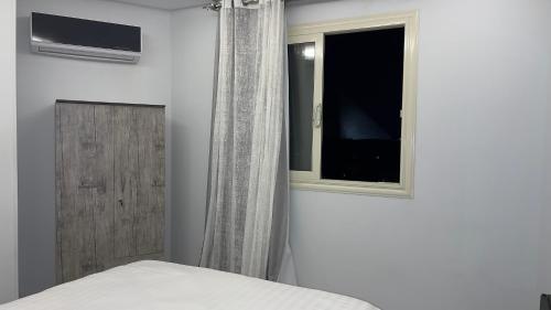 a bedroom with a bed and a window at Pyramids Tower view inn in Nazlat as Sammān