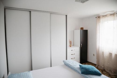 a bedroom with white cabinets and a black refrigerator at Apartmani Romić R in Novi Travnik