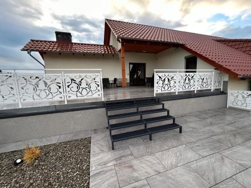 a house with a white fence and a patio at Restauracja & Bar u Dudy in Chrząstowice