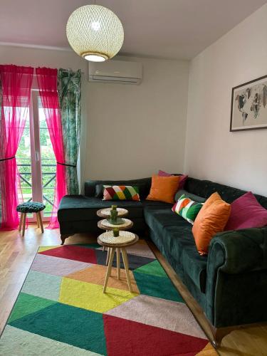 a living room with a green couch and a colorful rug at Apartman AURORA CETINJE in Cetinje