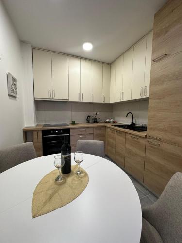 a kitchen with a table with two wine glasses on it at Apartman AURORA CETINJE in Cetinje