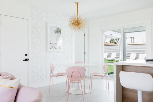 a dining room with pink chairs and a table at Palm Vista by Rather Be Properties in Palm Springs