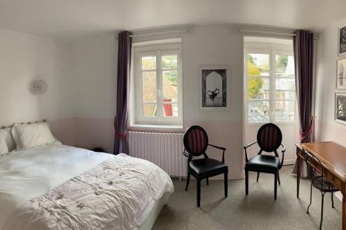 une chambre avec un lit et deux chaises et un bureau dans l'établissement Pink Pearl Trouville, à Trouville-sur-Mer