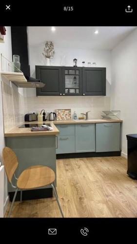 Il comprend une cuisine avec des placards bleus et du parquet. dans l'établissement Pink Pearl Trouville, à Trouville-sur-Mer