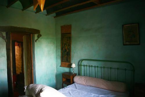 een slaapkamer met een bed en een groene muur bij Château de Favols, gite sur Lot (Lot et Garonne) in Bias