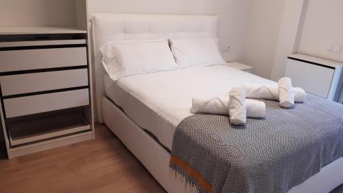 ein kleines Schlafzimmer mit einem Bett mit Handtüchern darauf in der Unterkunft Nuevo con Piscina en el centro y cerca de la playa in Vilanova i la Geltrú