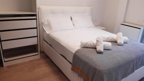 a small bedroom with a bed with towels on it at New beside Sitges with pool beside beach in Vilanova i la Geltrú