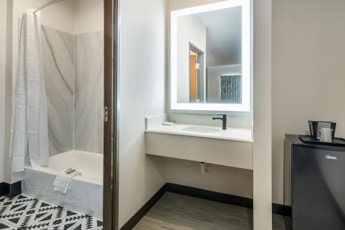 a bathroom with a shower and a sink and a mirror at Scottish Inns- Forest Hill in Forest Hill
