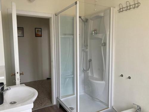 baño blanco con ducha y lavamanos en Casa Riva, en Crema