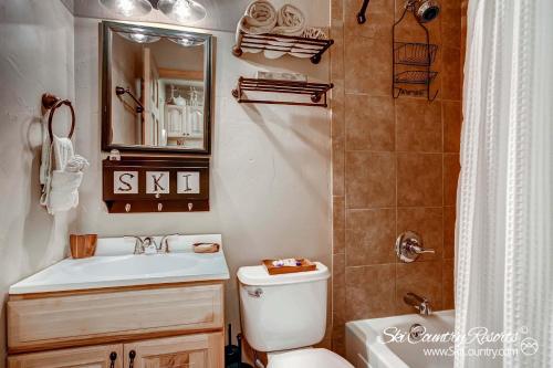 a bathroom with a toilet and a sink and a mirror at Outstanding Top Floor Condo, Stunning Updates with Meticulous Touches Throughout PM7C in Breckenridge