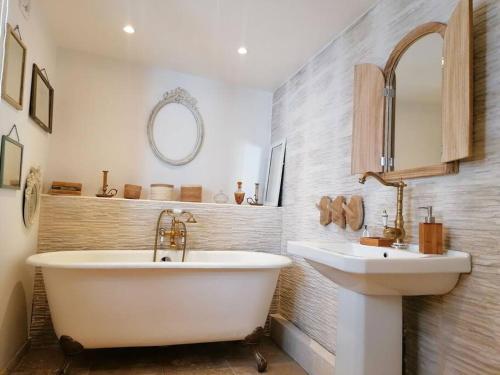 ein Badezimmer mit einer weißen Badewanne und einem Waschbecken in der Unterkunft Chez mamie framboise centre ville avec courette in Dieppe