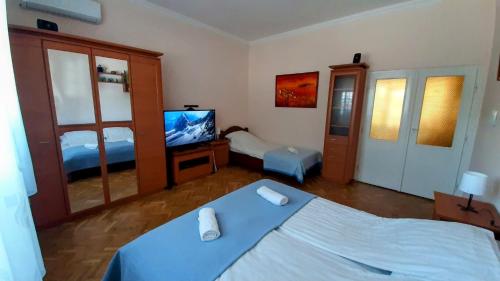 ein Schlafzimmer mit einem Bett und einem TV in der Unterkunft MIMO APARTMAN in Hajdúszoboszló