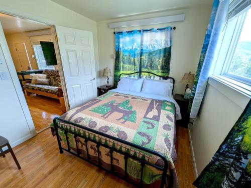 a bedroom with a bed with a quilt on it at Yellowstone Treasure Guesthouses on the River in Gardiner
