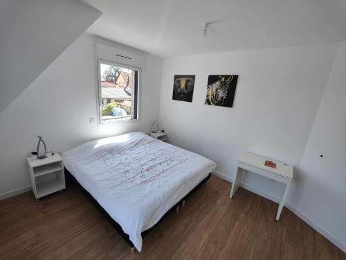 a white bedroom with a bed and a window at Appartement 48m², Strasbourg centre à 15 min en train in Fegersheim