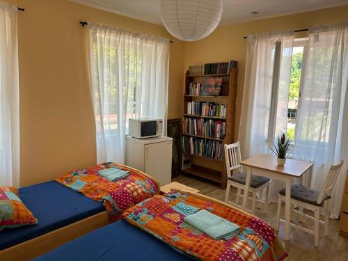 een slaapkamer met een bed en een tafel met een tv bij Burgfreiheit in Heidelberg