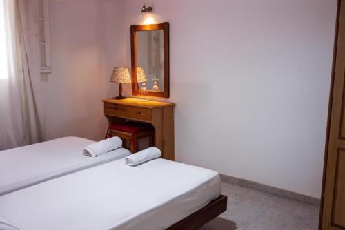 a bedroom with two beds and a mirror and a lamp at Katerina Studios & Apartments in Sidari
