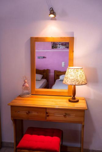 a desk with a mirror and a lamp on it at Katerina Studios & Apartments in Sidari