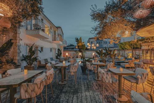 ein Restaurant mit Tischen und Stühlen auf einer Terrasse in der Unterkunft Rupa Otel Alacatı- Adults Only in Izmir
