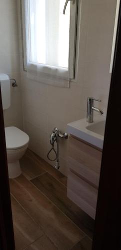 baño con aseo y lavabo y ventana en La Maison de André en Scaltenigo
