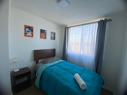 ein Schlafzimmer mit einem blauen Bett und einem Fenster in der Unterkunft Apartamento boldo Curicó in Curicó