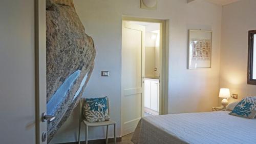 a bedroom with a bed and a chair in it at La Maddalena Exclusive villas in La Maddalena