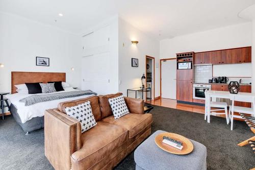 a living room with a couch and a bed at Princes Wharf Boutique Apartments in Auckland