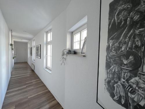 un couloir avec des murs blancs et une peinture murale dans l'établissement NeuWerk, à Erfurt
