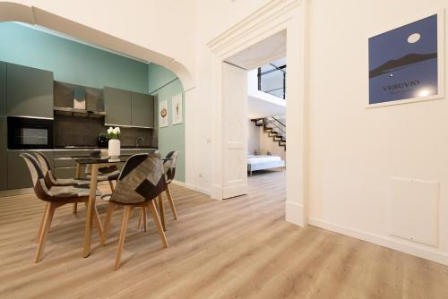 una cucina e una sala da pranzo con tavolo e sedie di Guest House 121 Luxury Apartments a Napoli