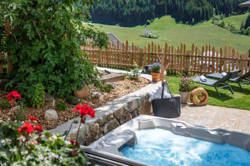 a garden with a hot tub in a yard at Oberkantiolhof in Villnoss