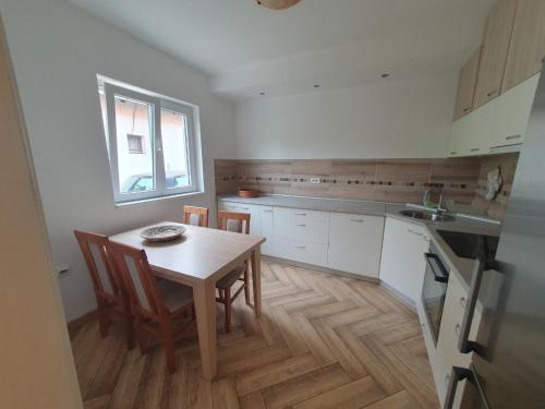 eine Küche mit einem Tisch und Stühlen sowie einem Fenster in der Unterkunft Apartment Pegy in Novi Grad