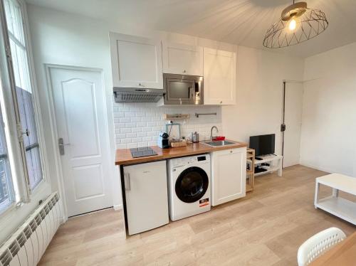 een keuken met een wasmachine in de kamer bij Le nid doux - proche Paris & métro in Villejuif