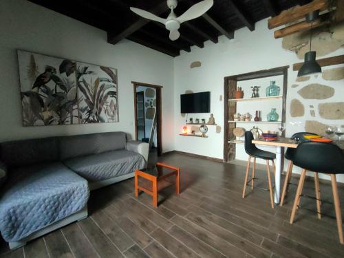 een woonkamer met een bank, een tafel en een bureau bij Casita Aljibe in San Miguel de Abona