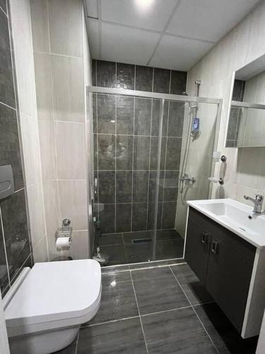 a bathroom with a shower and a toilet and a sink at BUREAU RESİDENCE STÜDYO DAİRE in Kartepe