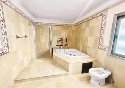 y baño con bañera, aseo y lavamanos. en Exclusive 3 BDR, Gym & Pool, SeaView, Luxury Tower, en Santo Domingo