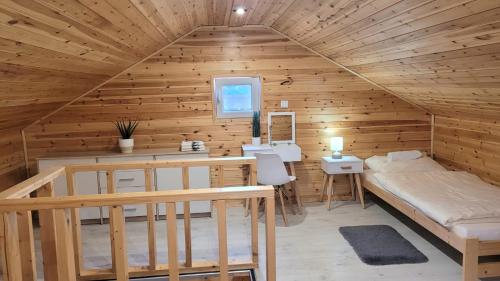 a room with a bed and a desk in a cabin at Wierzbowa Ostoja - Domek letniskowy BOSMAN in Karsibór