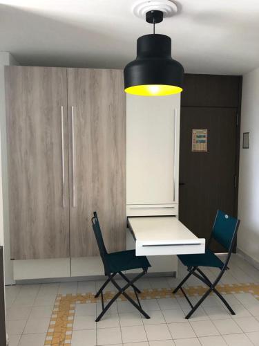 a dining room with a table and two chairs at Studios FREEBROISE in Saint-François